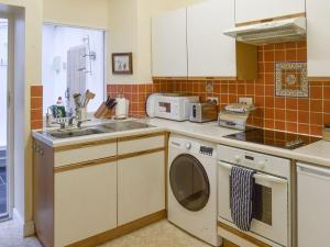 a kitchen with a sink and a washing machine at Begbie Cottage in Bowness-on-Windermere