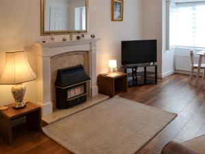 een woonkamer met een open haard en een televisie bij Glendalough in Hunmanby