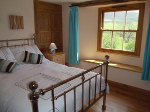 a bedroom with a bed and a window at Gateside Farmhouse Sedbergh in Sedbergh
