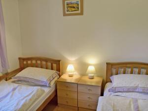 two beds in a bedroom with two lamps on a dresser at Tanglewood - E3092 in Thorpe Market