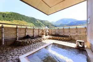 a hot tub with a view of the mountains at Bankokuya in Tsuruoka