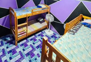 a bedroom with two bunk beds and a fan at Yuzon Bedspace Transient Home & Staycation in Manila