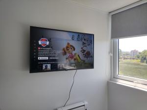 TV de pantalla plana colgada en la pared en Departamento estudio3 IslaTeja en Valdivia