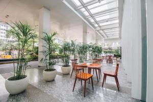 une salle avec des tables, des chaises et des plantes en pot dans l'établissement JS Luwansa Hotel & Convention Center, à Jakarta