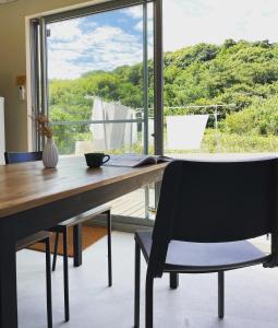 a wooden desk with a chair and a window at ゲストハウス and BAR CHITEN in Awaji +31 photos