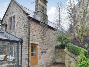 a brick house with a chimney on top of it at The Old Vicarage in Curbar