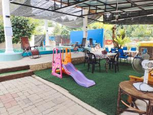 a playground with a slide and a table and chairs at Chalet Kampung Yan (OFFICIAL) in Yan