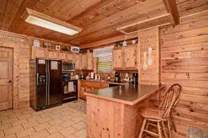 a kitchen with wooden cabinets and a black refrigerator at *Family friendly cabin near Dollywood! in Pigeon Forge