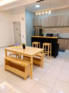 a kitchen with a table and stools in it at Adelia Wonderstay in Kajang