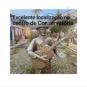 a statue of a man holding a guitar at Pousada no Centro de Conservatória Sandrinho ChicChic in Conservatória