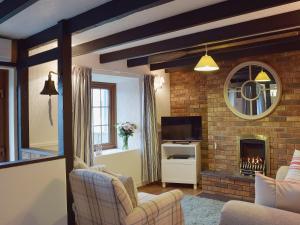 a living room with a fireplace and a tv at Ty Capel Seion in Cardigan