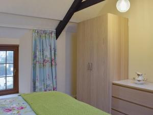 a bedroom with a green bed and a window at Ty Capel Seion in Cardigan