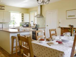 a kitchen with a table with a tablecloth on it at Islabank Farmhouse - Saap in Kirkton of Airlie