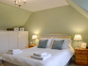 a bedroom with a white bed with towels on it at Islabank Farmhouse - Saap in Kirkton of Airlie