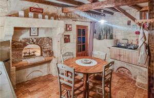ein Esszimmer mit einem Tisch und einem Steinkamin in der Unterkunft Stunning Home In Saint-sulpice-de-cogna With Kitchen in Saint-Sulpice-de-Cognac