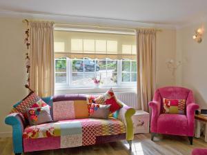a living room with a couch and a window at Captains Cottage - 27888 in Winterton-on-Sea