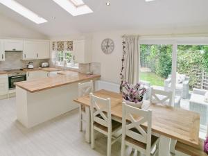 a kitchen and dining room with a table and chairs at Captains Cottage - 27888 in Winterton-on-Sea