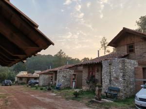 a group of buildings with cars parked in front of them at Luchita Mia Eco Cabañas Boutique in Zacatlán