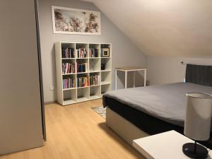 a bedroom with a bed and a book shelf with books at Cozy 120m² Apartment with 3 Bedrooms and 1 Home Cinema in Useldange