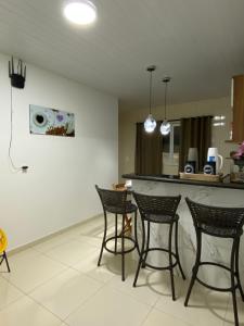 una cocina con 4 sillas y un bar en una habitación en Conchas de Maragogi, en Maragogi