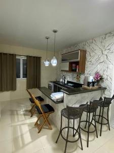 a kitchen with chairs and a counter in a room at Conchas de Maragogi in Maragogi