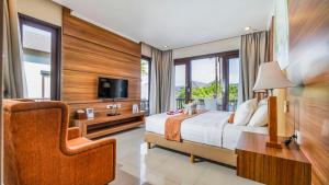 a bedroom with a bed and a chair and a tv at Sotis Villas in Canggu +46 photos