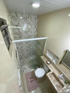 a bathroom with a toilet and a glass shower at Conchas de Maragogi in Maragogi