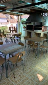 un patio con mesas, sillas y fogones en Hostal New Do Rio, en Maitencillo