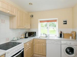 a kitchen with a sink and a dishwasher at The Stable in Foxham
