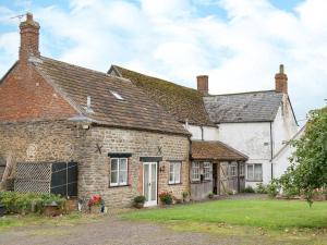 an old stone house with a yard at The Stable in Foxham