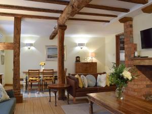 Lovely Old Cottage في ستراتفورد أبون آفون: غرفة معيشة مع أريكة وطاولة
