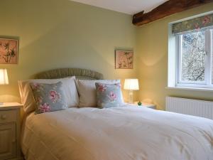Lovely Old Cottage في ستراتفورد أبون آفون: غرفة نوم بسرير ابيض مع مخدات ونافذة