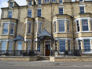 a large brick building with a brown door at The Nest - 9 The Landings in Filey