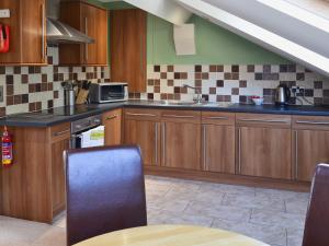 a kitchen with wooden cabinets and a sink at The Nest - 9 The Landings in Filey