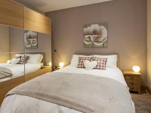a bedroom with two beds and two pictures on the wall at Two The Old Stables in Knitsley
