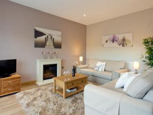 a living room with a couch and a fireplace at Two The Old Stables in Knitsley