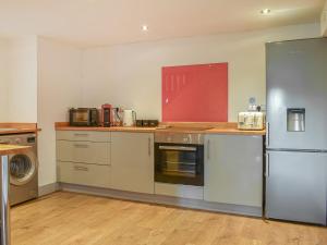 Hay Loft - Uk37423 في Langtree: مطبخ مع دواليب بيضاء وثلاجة