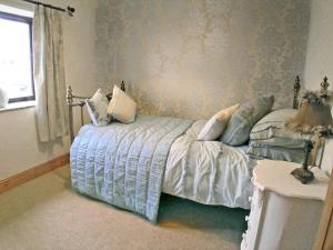 a bedroom with a bed with pillows on it at Rundales Cottage in Appleby