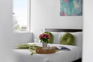 uma cama branca com uma mesa com um vaso de flores em Bright and Sunny Gem on Hotham em Melbourne