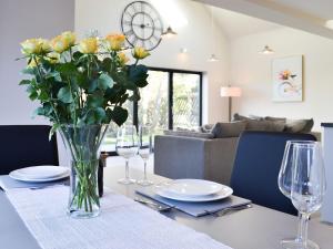 a dining room table with a vase of flowers on it at The Carriage House in Upper Poppleton