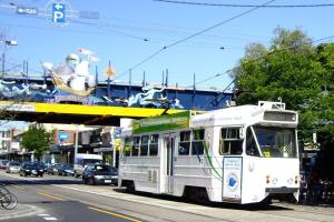 um autocarro branco a descer uma rua da cidade em Bright and Sunny Gem on Hotham em Melbourne