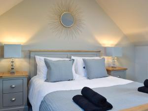 a bedroom with a large bed with a mirror on the wall at The Carriage House in Upper Poppleton