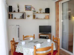 a dining room with a table and a television at Appartement Gruissan, 2 pièces, 4 personnes - FR-1-229-98 in Gruissan