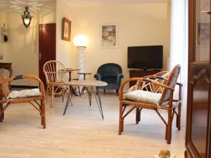 - un salon avec des chaises, une table et une télévision dans l'établissement Appartement La Rochelle, 2 pièces, 4 personnes - FR-1-246-301, à La Rochelle