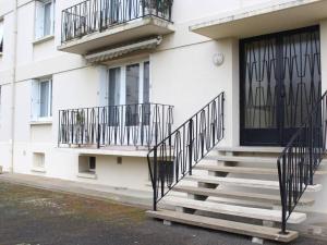 - un bâtiment blanc avec des escaliers et des balcons dans l'établissement Appartement La Rochelle, 2 pièces, 4 personnes - FR-1-246-301, à La Rochelle