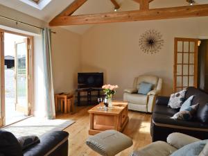 a living room with couches and a table at Llanlliwe Cottage in Henllan Amgoed