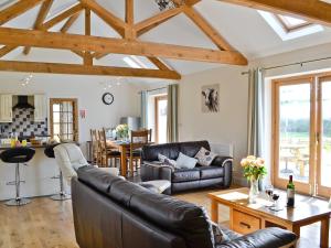 a living room with a couch and a table at Llanlliwe Cottage in Henllan Amgoed