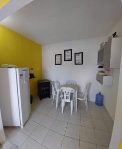 FLAT DA DANI Galinhos RN في غالينوس: مطبخ مع طاولة وكراسي وثلاجة