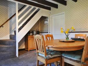 a dining room with a wooden table and stairs at Castle View in Wykeham