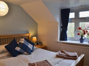 a bedroom with a bed with a window and towels on it at Castle View in Wykeham